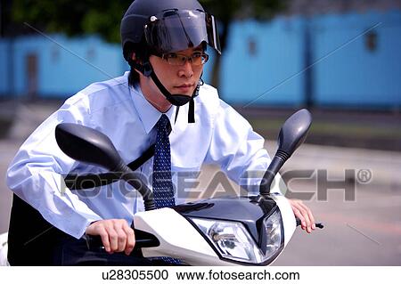 Stock Image - Young businessman riding motorcycle. Fotosearch
