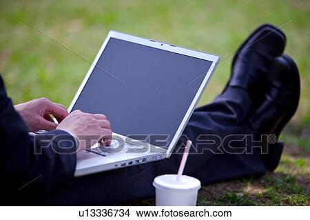 Young businessman using laptop, focus on low section View Large Photo Image Picture - Young businessman using laptop, focus on low section. Fotosearch