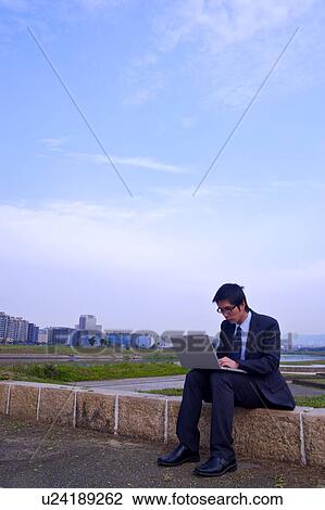 Young businessman using laptop outdoors View Large Photo Image Stock Image - Young businessman using laptop outdoors. Fotosearch