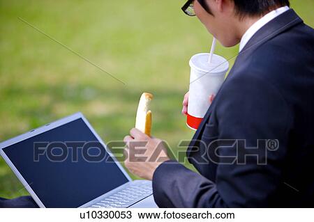 Young woman eating food with laptop View Large Photo Image Stock Image - Young woman eating food with laptop. Fotosearch