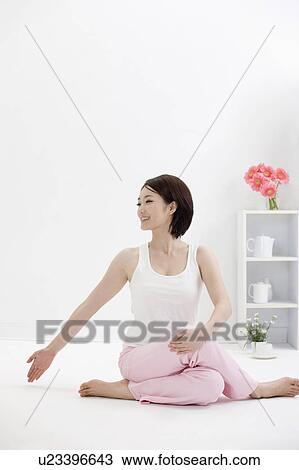 Stock Image - Young woman doing yoga and looking away. Fotosearch