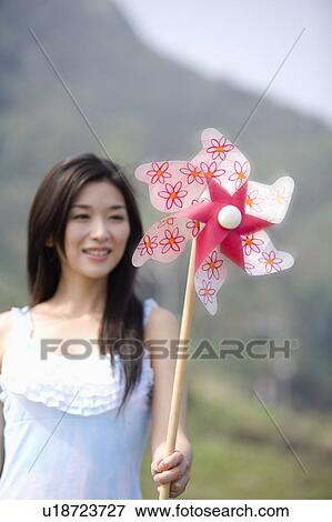 Stock Photo - Young woman holding a pinwheel. Fotosearch