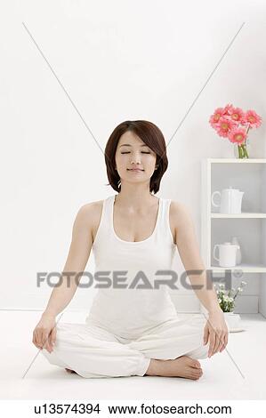 Picture - Young woman making lotus position and having contemplation. Fotosearch