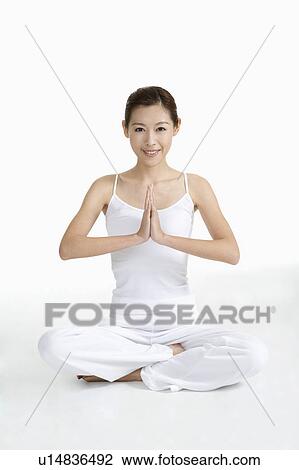 Young woman making lotus position and looking at the camera View Large Photo Image Stock Image - Young woman making lotus position and looking at the camera. Fotosearch