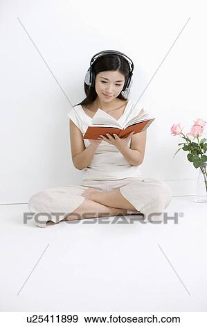Young woman reading a book and listening music View Large Photo Image Stock Photo - Young woman reading a book and listening music. Fotosearch