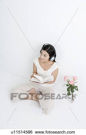 Young woman reading book and listening to music View Large Photo Image Stock Photograph - Young woman reading book and listening to music. Fotosearch