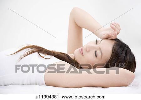 Stock Image - Young woman resting with eyes closed. Fotosearch