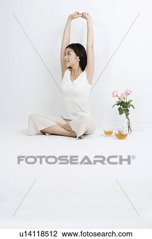 "Young woman sitting, stretching and looking away" View Large Photo Image Stock Image - "Young woman sitting, stretching and looking away". Fotosearch