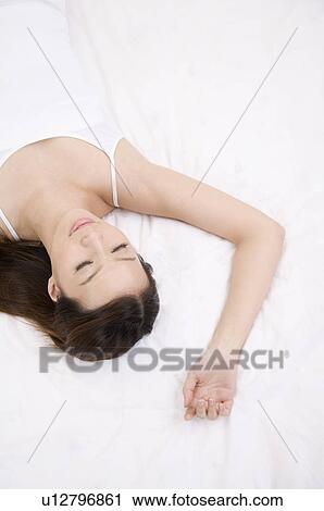 Stock Image - Young woman sleeping with eyes closed. Fotosearch