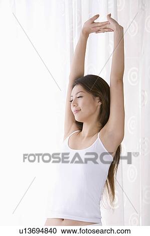 Young woman stretching and closing her eyes View Large Photo Image Stock Image - Young woman stretching and closing her eyes. Fotosearch