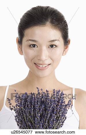 Stock Photo - "Young woman with lavender, portrait". Fotosearch
