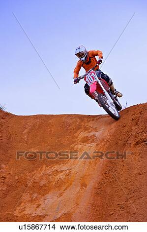 Picture - Young man motocross over field.. Fotosearch