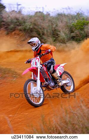 Picture - Young man motocross over field.. Fotosearch