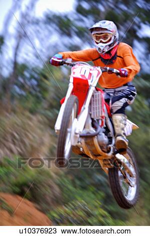 Stock Image - Young man motocross over field.. Fotosearch