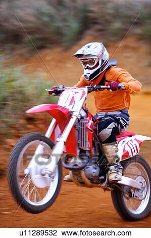 Stock Image - Young man motocross over field.. Fotosearch