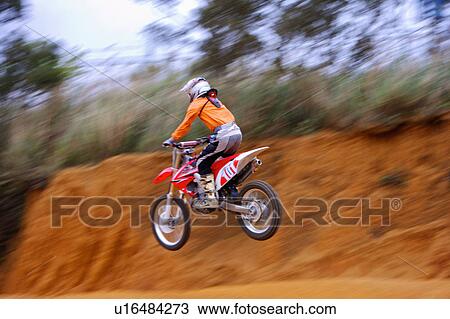 Stock Image - Young man motocross over field.. Fotosearch