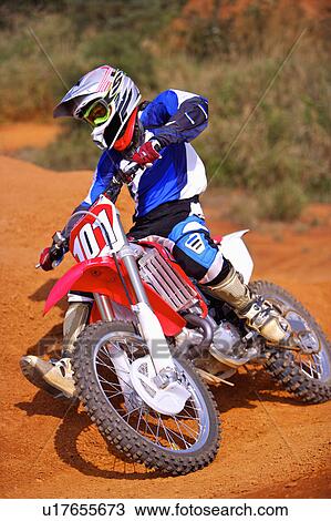 Stock Image - Young man motocross over field.. Fotosearch