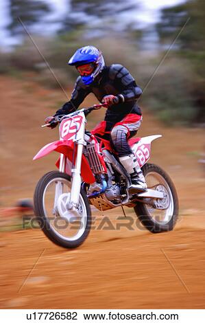 Stock Image - Young man motocross over field.. Fotosearch