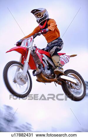 Stock Image - Young man motocross over field.. Fotosearch