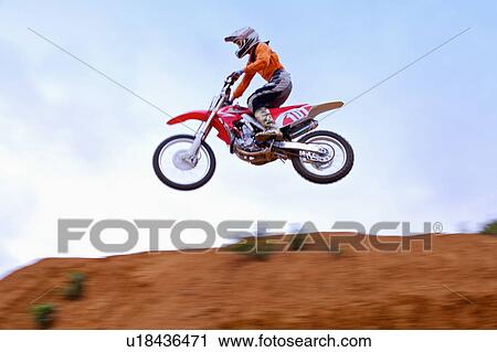 Stock Image - Young man motocross over field.. Fotosearch
