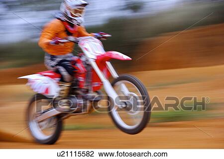 Stock Image - Young man motocross over field.. Fotosearch