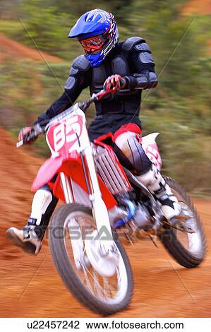 Stock Image - Young man motocross over field.. Fotosearch