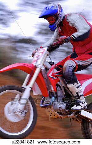 Stock Image - Young man motocross over field.. Fotosearch