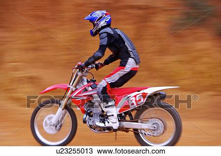 Stock Image - Young man motocross over field.. Fotosearch