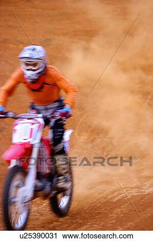 Stock Image - Young man motocross over field.. Fotosearch