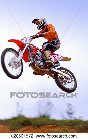 Young man motocross over field. View Large Photo Image Stock Image - Young man motocross over field.. Fotosearch