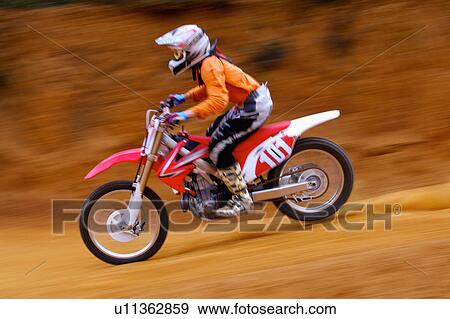 Stock Photo - Young man motocross over field.. Fotosearch