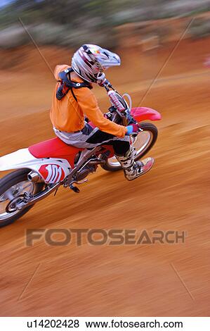 Stock Photo - Young man motocross over field.. Fotosearch