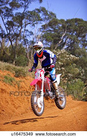 Stock Photo - Young man motocross over field.. Fotosearch
