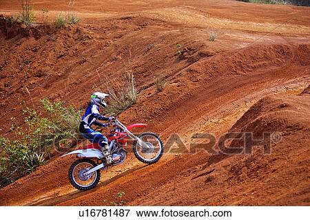 Stock Photo - Young man motocross over field.. Fotosearch