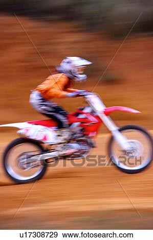 Stock Photo - Young man motocross over field.. Fotosearch
