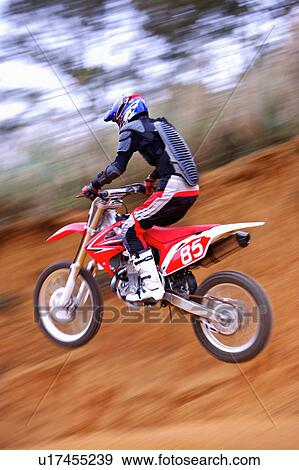 Stock Photo - Young man motocross over field.. Fotosearch
