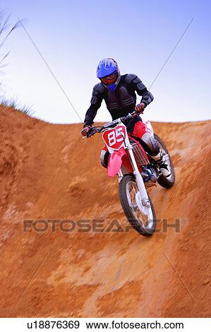 Stock Photo - Young man motocross over field.. Fotosearch