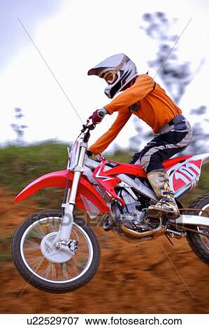 Stock Photo - Young man motocross over field.. Fotosearch
