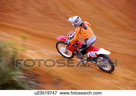 Stock Photo - Young man motocross over field.. Fotosearch