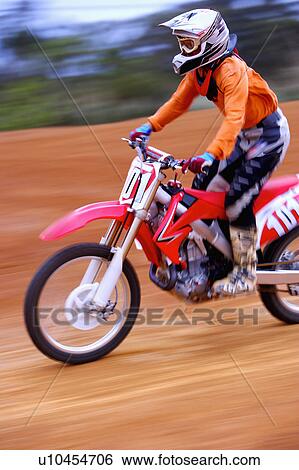 Stock Photograph - Young man motocross over field.. Fotosearch