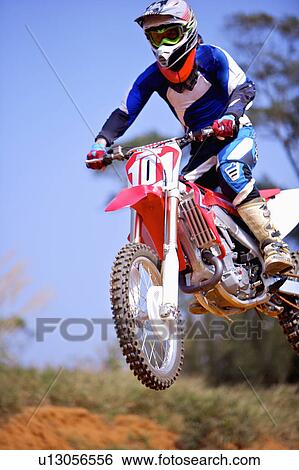 Stock Photograph - Young man motocross over field.. Fotosearch