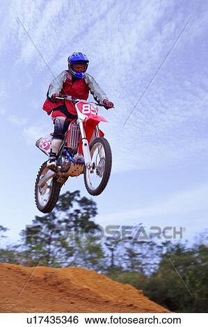 Young man motocross over field. View Large Photo Image Stock Photograph - Young man motocross over field.. Fotosearch