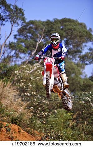Stock Photograph - Young man motocross over field.. Fotosearch