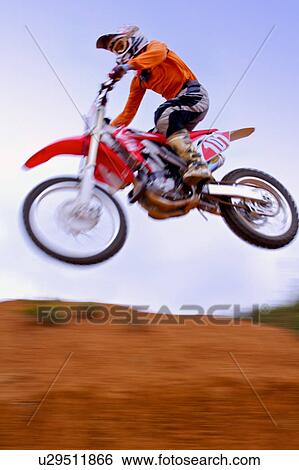 Stock Photograph - Young man motocross over field.. Fotosearch