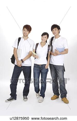 Stock Image - School boys and schoolgirl standing together with books and school bags. Fotosearch