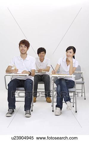 Stock Photography - Schoolboys and schoolgirl sitting in the classroom and studying. Fotosearch