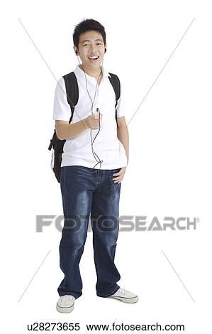 Stock Photography - "Teenager boy standing and listening music with school bag, portrait". Fotosearch