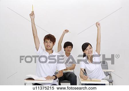 Three students sitting in classroom and raising hands View Large Photo Image Stock Photography - Three students sitting in classroom and raising hands. Fotosearch