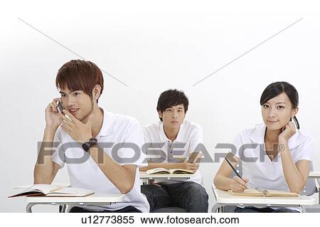 Stock Photography - Three students sitting in the classroom and studying. Fotosearch