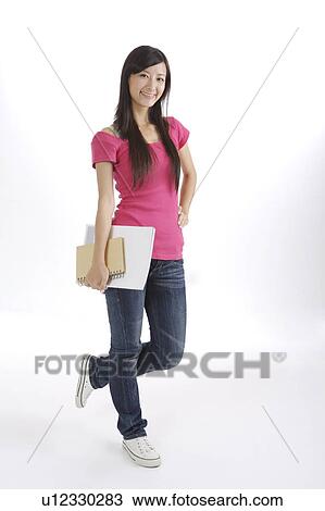 Stock Image - "Young girl holding book with one feet up, portrait". Fotosearch